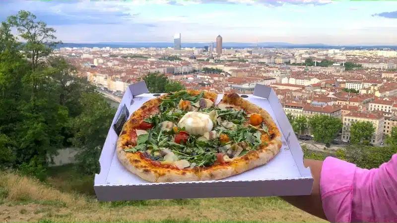 Pizza avec une vue sur Lyon depuis un parc.
